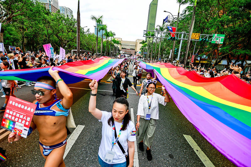 
People carry rainbow banners during the LGBTQ+ Pride parade in Taipei yesterday.
Photo: Daniel Ceng, EPA-EFE