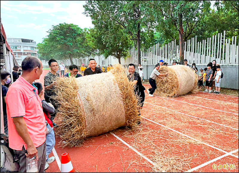 台中烏日區農會昨舉行稻米產業文化節，現場安排推稻草捲競賽，參加的隊伍都賣力推動稻草捲，現場趣味橫生。（記者陳建志攝）