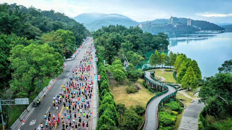 日月潭環湖馬拉松開跑，超過5000人路跑將環潭公路點綴得有如一條彩色巨龍。（日管處提供）