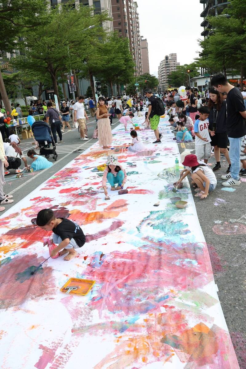 近白米長的白紙舖在馬路上，讓小朋友情塗鴉、彩繪。（高雄市教育局提供）