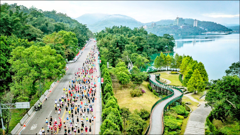 日月潭環湖馬拉松開跑，超過5000人路跑將環潭公路點綴得有如一條彩色巨龍。
（日管處提供）