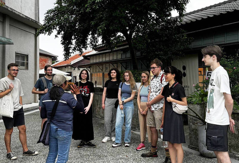 大溪文化觀光產業推展協會理事長黃淑君（前左）帶外國遊客導覽木博館。（黃淑君提供）