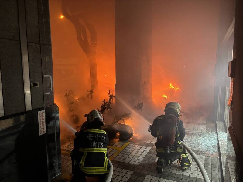 台中市北区民权路一间银行门前停放的汽机车凌晨起火，起火点疑似位于汽机车，之后延烧至骑楼等处。（台中市消防局提供）