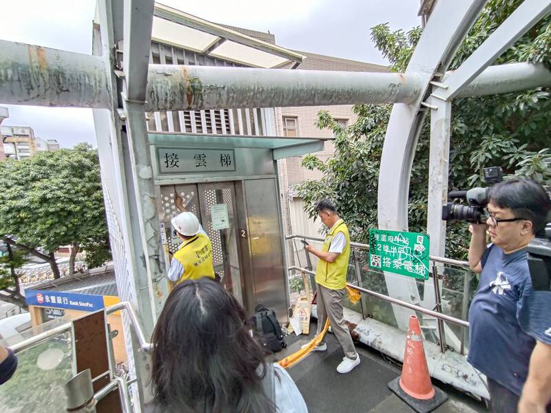 新北市板橋區府中商圈的遊龍陸橋景觀電梯日前突然墜落，造成2人受傷，板橋區公所與市府工務局、中華民國電梯升降設備協會、台灣省機械技師公會到現場會勘，初步判斷肇事原因為3條鋼索斷裂。（板橋區公所提供）