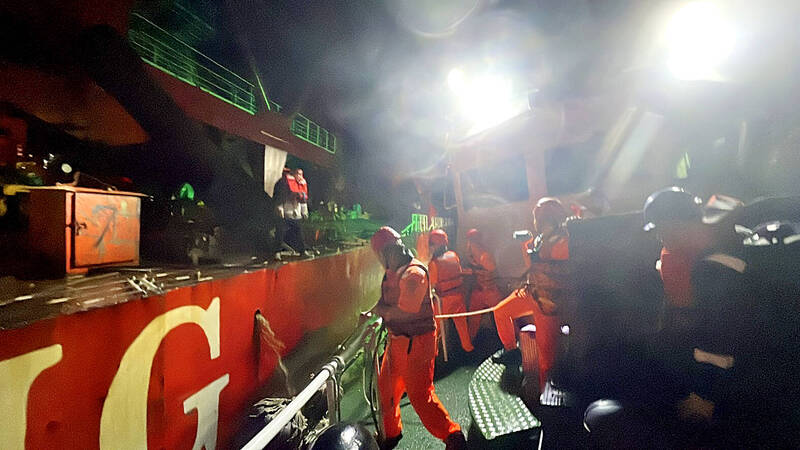 
Coast Guard Administration personnel work on board a patrol vessel alongside the Yu Zhou Qi Hang, a China-registered cargo ship, off New Taipei City’s Cape Yehliu on Tuesday.
Photo courtesy of the Coast Guard Administration