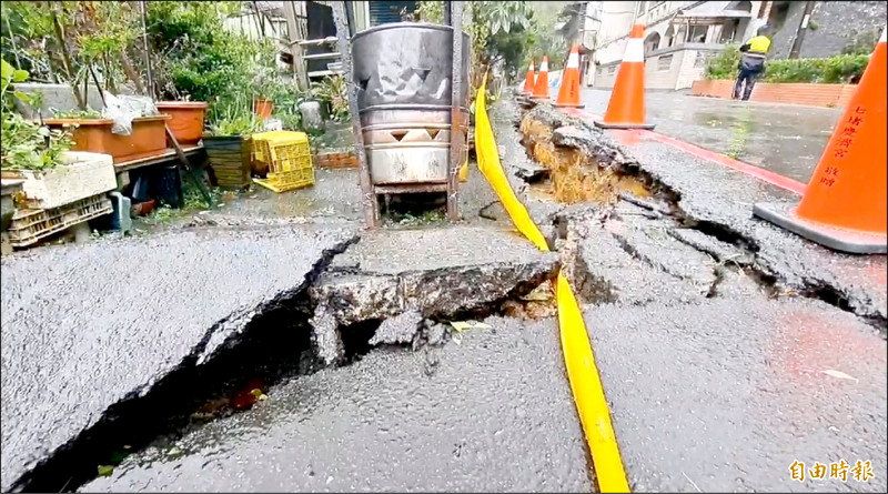 基隆市七堵區華新二路河岸邊坡下滑，導致路面龜裂。（記者盧賢秀攝）