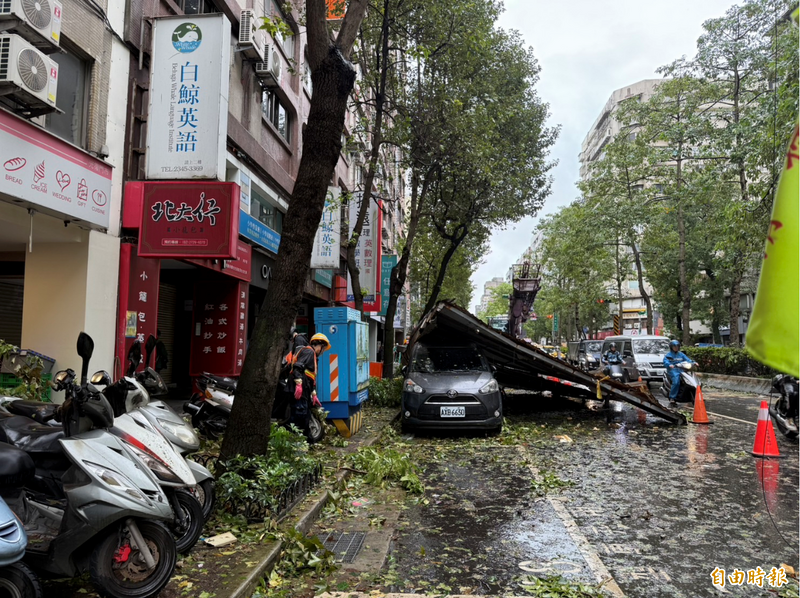 光復南路上有鐵皮掉落壓到車輛待移除，占據車道。（記者甘孟霖攝）