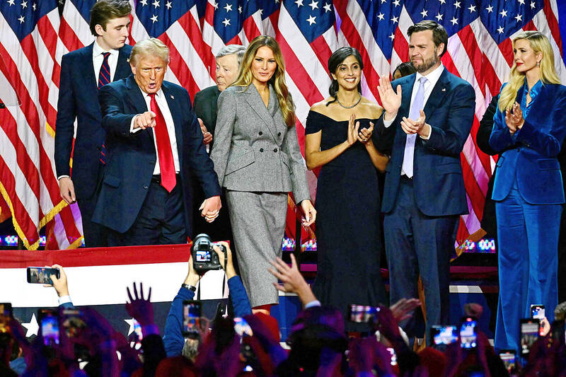 Former US president Donald Trump, second left, gestures as he holds hands with his wife, Melania Trump, at an election event at the West Palm Beach Convention Center in Florida early yesterday. Others on the stage include their son Barron Trump, left, US Senator J.D. Vance, second right, Trump’s running mate, and Vance’s wife, Usha, third right.
Photo: AFP