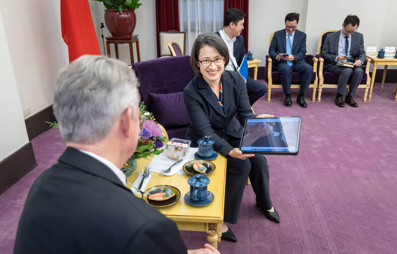 副總統蕭美琴以平版向美國愛達荷州長李睿德，介紹雲林科技大學學生製作的馬鈴薯塔。（總統府提供）