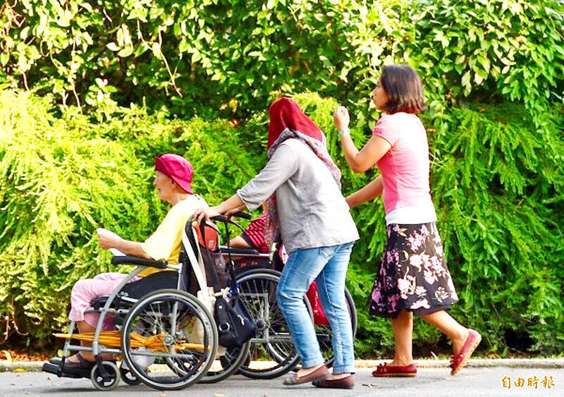 Caregivers push people in wheelchairs at a park in Taipei in an undated photograph.
Photo: Taipei Times