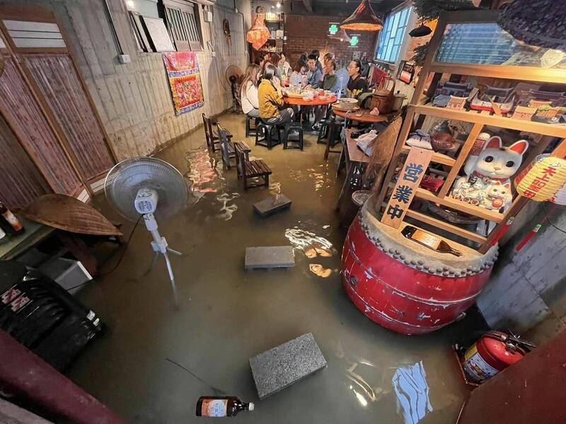 宜蘭遭雨彈襲擊，顧客淹水中用餐成另類「流水席」。（業者郭稟翰提供）