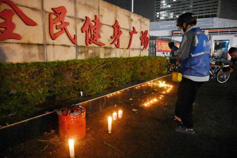 广东珠海市体育中心11日晚间发生越野车冲撞人群事件，造成35人死亡、43人受伤。12日晚民众到体育中心外摆放蜡烛悼念亡者。（法新社）