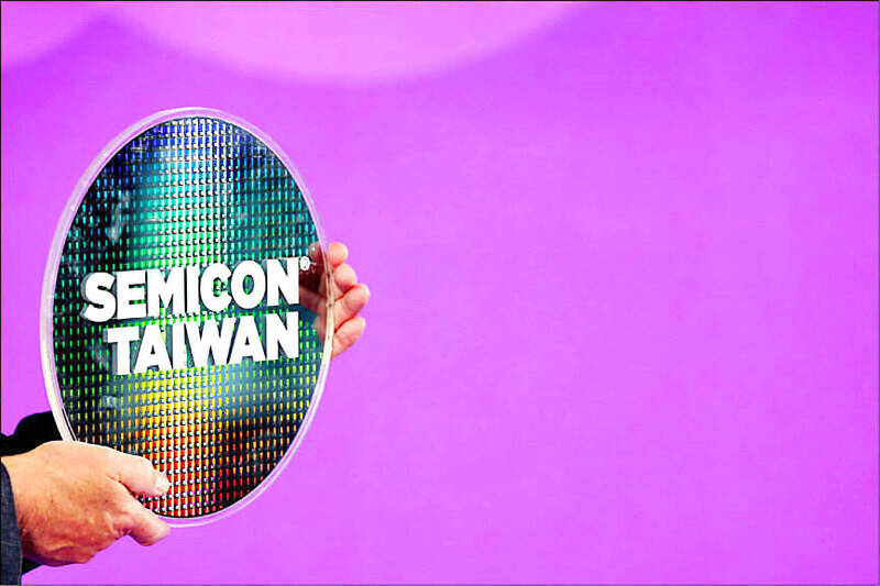 An undated photograph shows a person holding a silicon wafer with the words “Semicon Taiwan” on it.
Photo: Reuters