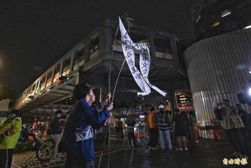 台北市和平新生天橋今晚11點開始拆除，民團舉起「招魂幡」，高喊「過橋喔」。（記者林正堃攝）