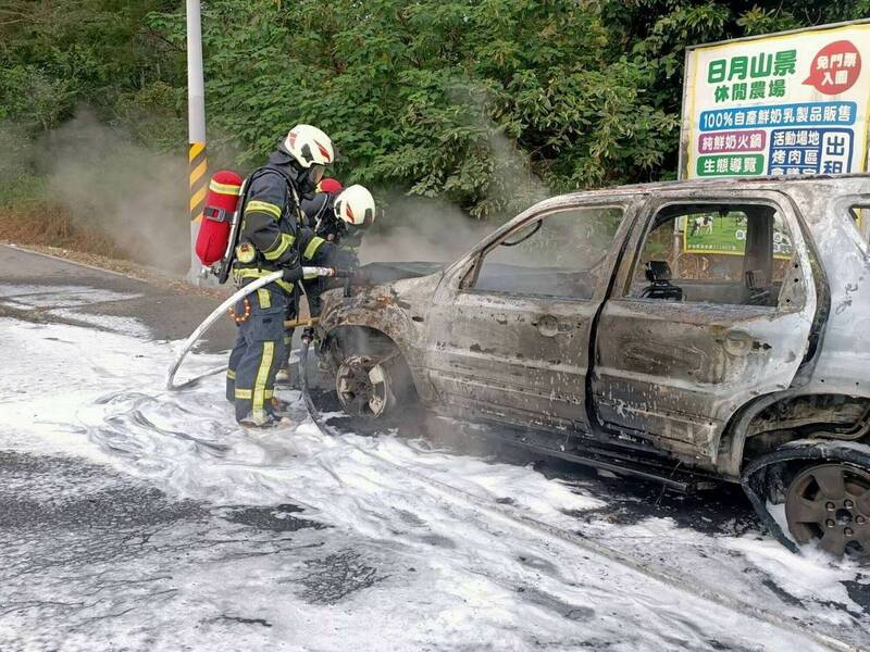 休旅車陷入火海，濃煙竄天，消防員噴灑泡沫水線灌救，整輛車燒成廢鐵。 （消防局提供）