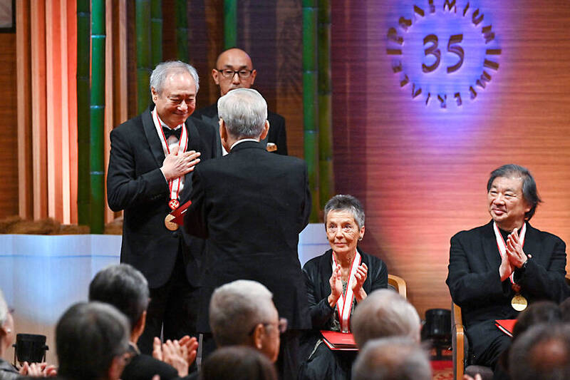 Taiwanese filmmaker Ang Lee, left, receives a testimonial letter and honorarium during the awards ceremony for Japan’s biggest arts award, the Praemium Imperiale, in Tokyo on Tuesday.
Photo: AFP