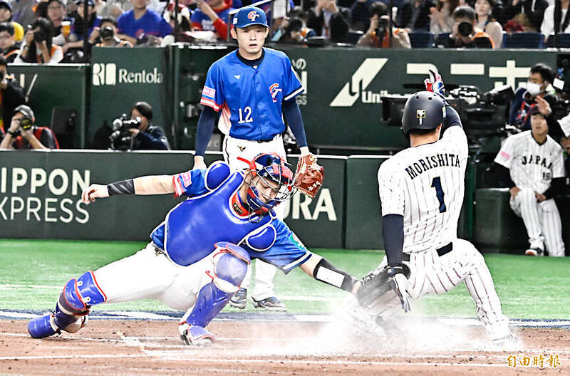 
Japan’s Shota Morishita, right, slides home during their WBSC Premier12 Super Round game against Taiwan in Tokyo last night.
Photo: Chen Chih-chu, Taipei Times