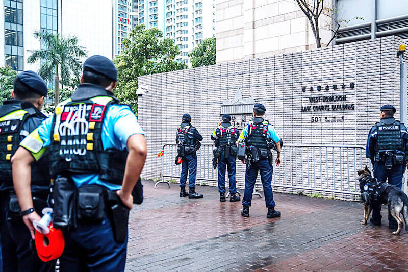 
Police officers stand guard outside the West Kowloon Court ahead of a sentencing hearing for 45 democracy activists in Hong Kong on Tuesday last week.
Photo: Bloomberg