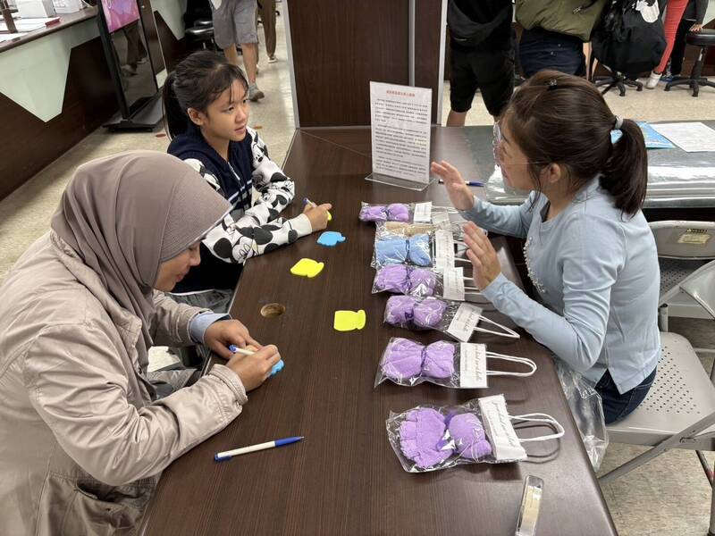 新北市服務站社工王文琍（右一）向印尼籍新住民母女介紹感恩節由來。（記者吳昇儒翻攝）