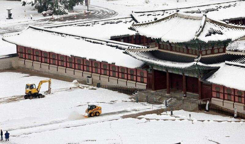 南韩持续大雪，图为首尔景福宫在进行除雪工作。（韩联社）