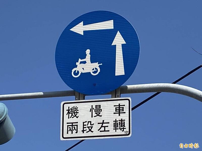 依規定，道路路口號誌桿上懸掛「機慢車兩段左轉」標誌，機車用路人行經該路口，就要強制兩段左轉通行，違規受罰。（記者張聰秋攝）