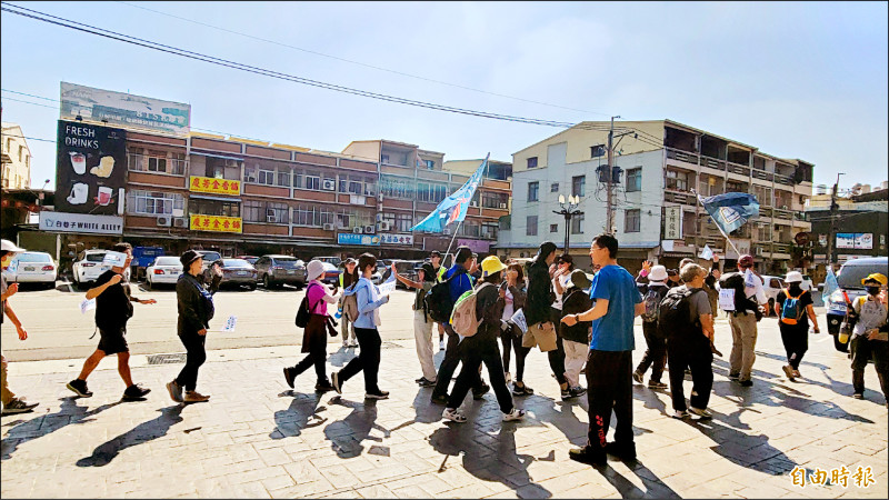 民眾抵達台南西港慶安宮，前後站成員擊掌接力後繼續往北走。（記者王姝琇攝）