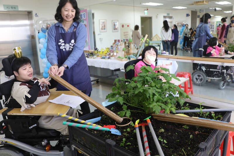 台灣園藝輔助治療協會理事長張博然利用剖開的竹筒讓翁彥如播種。（圖由新北市社會局提供）