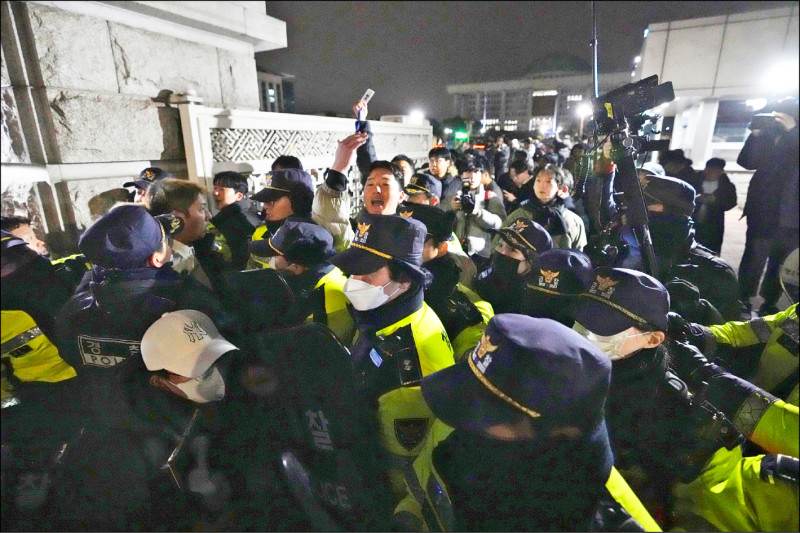 南韓總統尹錫悅3日宣布緊急戒嚴，警察在國會前進行戒備，與民眾發生衝突。（路透）