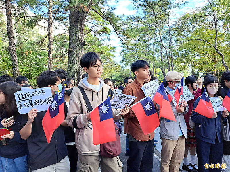 
People hold Taiwanese flags and placards at a protest at National Tsing Hua University in Hsinchu yesterday.
Photo: Hung Mei-hsiu, Taipei Times