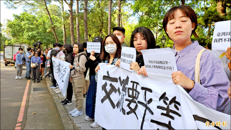 由馬英九基金會邀請的中生訪問團，昨天到新竹清華大學參訪，多名清大學生一早就以長達150公尺的人龍舉牌及拿國旗表達立場。（記者洪美秀攝）