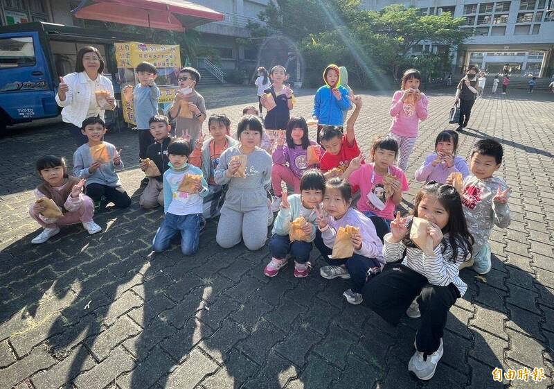 台中霧峰國小家長會鼓勵小朋友閱讀，安排車輪餅餐車進校園，小朋友開心吃到熱騰騰的車輪餅。（記者陳建志攝）