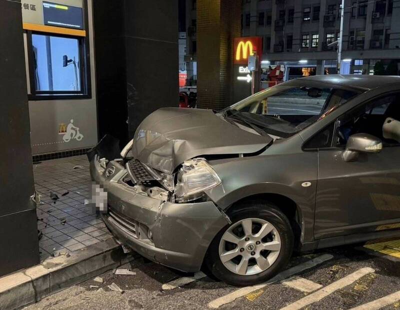 轎車衝入麥當勞得來速車道，撞擊到柱子後停住，車頭毀損駕駛未受傷。 （民眾提供）