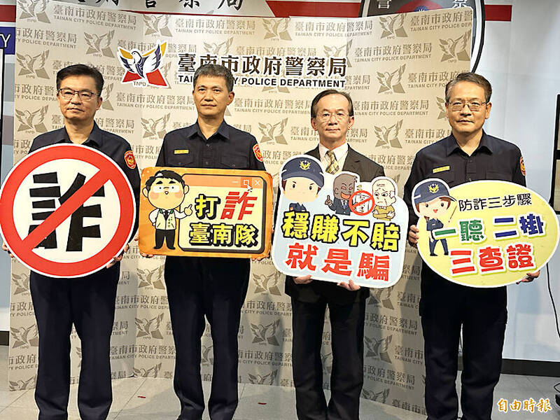 Police officers hold placards with anti-fraud messages at a press conference in Taipei on Nov. 14.
Photo: Liu Wan-lin, Taipei Times