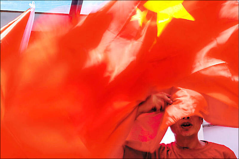 A person’s face is covered by a Chinese flag fluttering in the wind in Beijing in an undated photograph.
Photo: Bloomberg