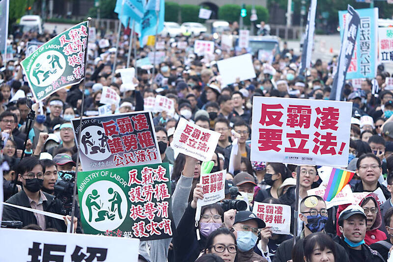 Participants hold up placards during a march held by the Taiwan People’s Party in Taipei yesterday on workers’ rights.
Photo: CNA