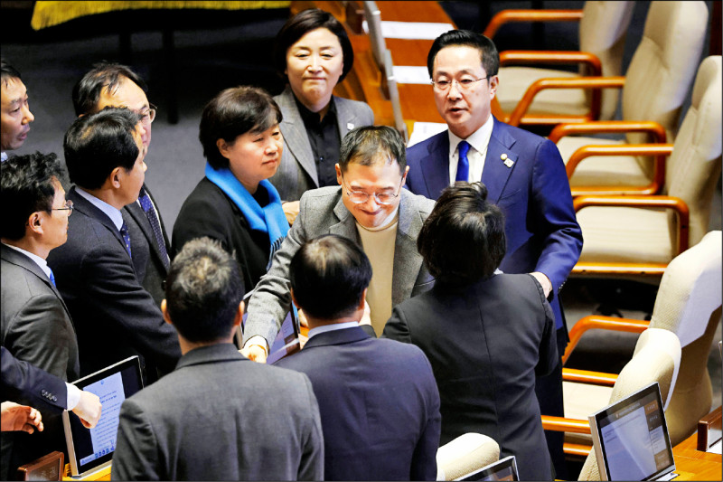 南韓執政黨國會議員金相昱（中）7日忤逆黨團抵制彈劾的決議，現身國會參加對尹錫悅總統的彈劾投票，受到在野黨議員的歡迎。（美聯社）