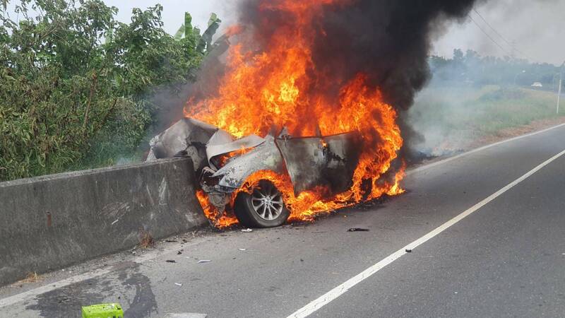 小轎車撞進水泥護欄起火燃燒。（屏東縣消防局提供）