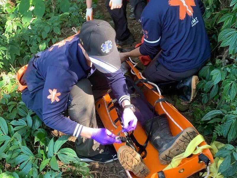 溪頭鳳凰山有山友登山身體不適，經檢查發現有心肌梗塞情況，消防人員緊急接力搬運下山送醫。（南投縣消防局提供）