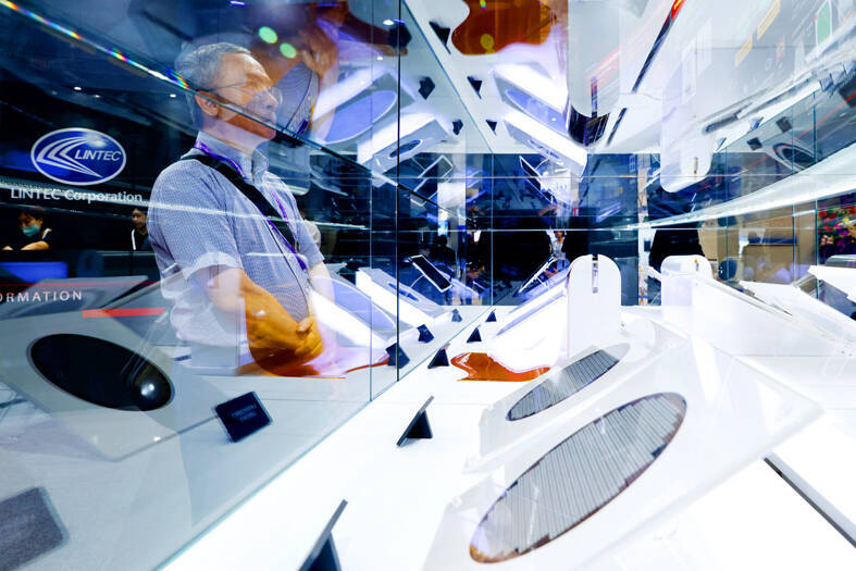 
Visitors inspect silicon wafers on display at the SEMICON Taiwan show at the Nangang Exhibition Center in Taipei on Sept. 4.
Photo: Ritchie B. Tongo, EPA-EFE