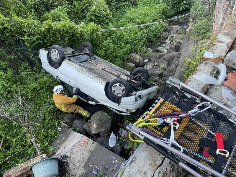 一輛轎車翻落溪谷事件，消防人員獲報前往救援。（圖由民眾提供）