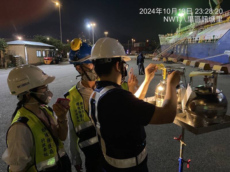 新北市環保局聯合稽查印尼船案，環保局檢驗人員於船尾採樣。（新北市環保局提供）