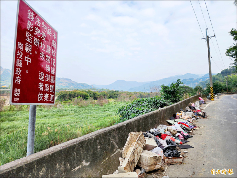 草屯鎮投12線車流少，沿路被亂丟廢棄物，連嚴禁傾倒垃圾的告示牌下方都是一堆垃圾，與九九峰隔烏溪相望。（記者陳鳳麗攝）