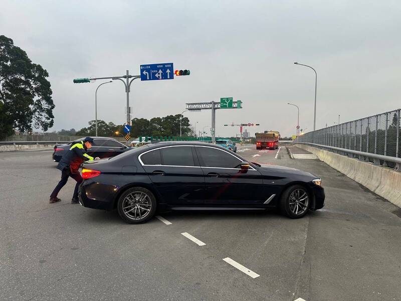 廖姓男子今早開車從台北行駛國道3號南下，行經桃園市龍潭路段途中發現引擎異常，駛出匝道後車輛突然熄火，停在路中央，熱心員警協助徒手將拋錨車輛推往路旁，順利解圍。（龍潭警分局提供）