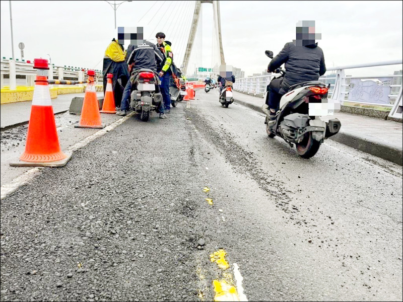 新北大橋進行機車道改善工程，疑因瀝青碎石，導致多名騎士經過時打滑摔車。（三重警分局提供）