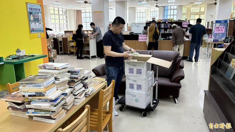 有台北的民眾專程開車下來選購藏書，桌上擺滿選購好的。（記者楊金城攝）