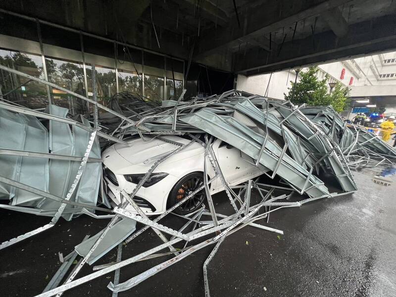 山陀兒颱風登陸高雄當天，蔡小姐的白色賓士轎車，被長庚醫學大樓雨遮的輕鋼架直接砸中。（蔡小姐提供）