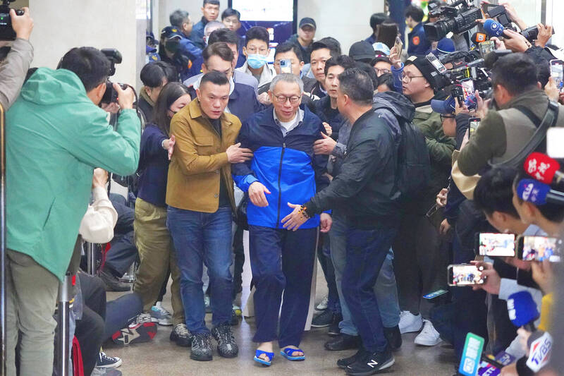 Taiwan People’s Party Chairman Ko Wen-je, center, is escorted out of the Taipei District Court in Taipei yesterday after being released on NT$30 million bail.
Photo: CNA