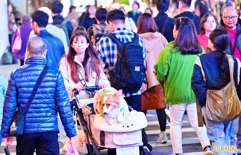 People in winter clothing in Taipei are pictured yesterday.
Photo: Liu Hsin-de, Taipei Times