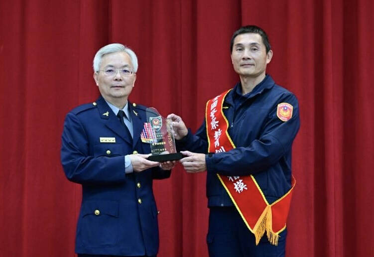 台南新營警分局教官程宥富（右）獲得年度警察教育訓練楷模殊榮，由警政署長張榮興（左）頒獎。（分局提供）