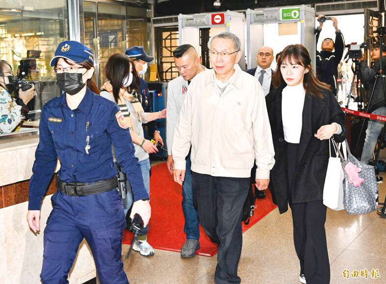 Taiwan People’s Party Chairman Ko Wen-je, center, arrives at the Taiwan District Court yesterday.
Photo: Lo Pei-de, Taipei Times